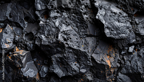 Dark volcanic basalt rock texture with a very rough and porous surface