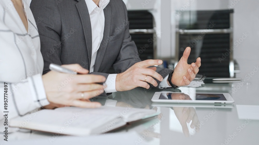 Fototapeta premium Business people hands discussing data on digital tablet during an office meeting, planning strategy and analyzing results