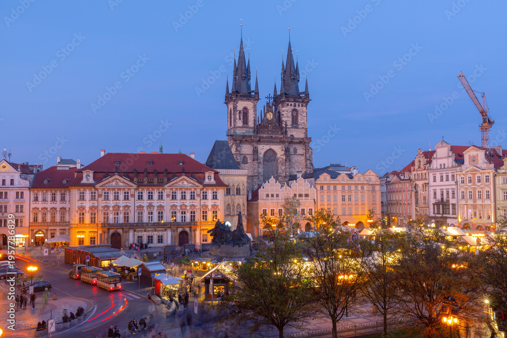 Obraz premium Old Town Square in Prague with historic buildings and Church of Our Lady before Tyn at dawn with early lights and market stalls.