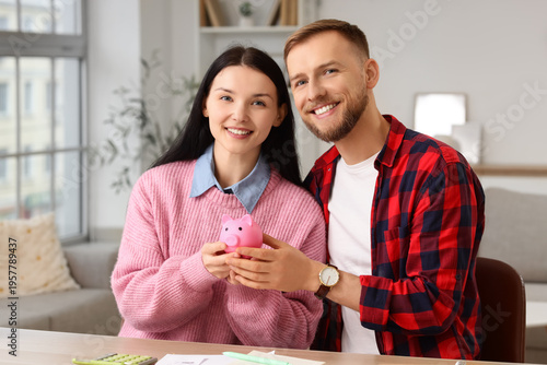 Young couple with piggy bank planning budget at home