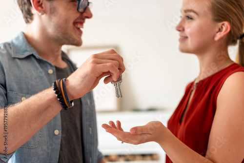 Billede på lærred Couple exchanging house keys happily