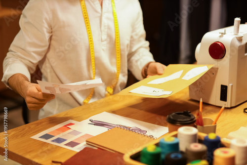 Male tailor with drawings a...