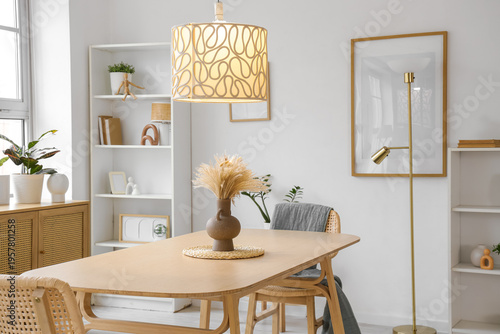 Tableau sur toile Interior of stylish dining room with wooden table, pampas grass and glowing lamp
