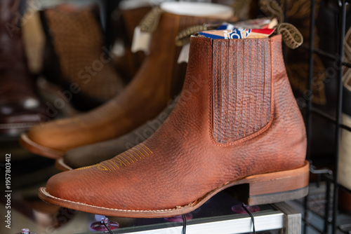 Fotografia The shelf with multiple new cowboy boots on display for sale at a retail store