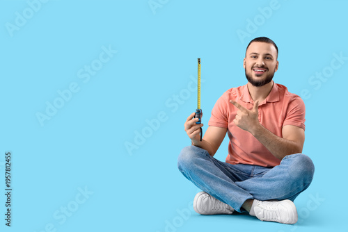 Young man pointing at measu...