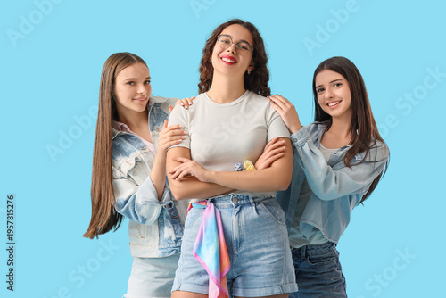 Happy teenage girls on blue...