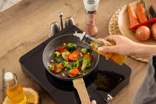Woman frying vegetables wit...
