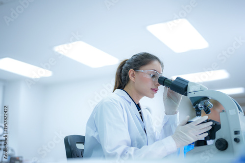 Bilde på lerret Focused female scientist using a microscope to examine biological samples in a sterile research laboratory