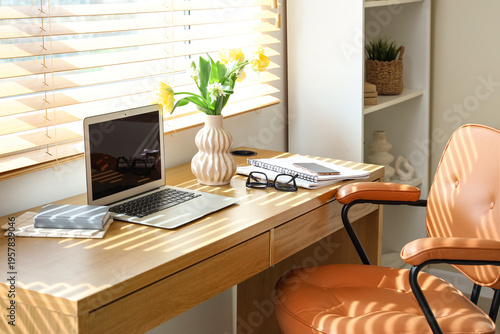 Blank laptop and vase with ...