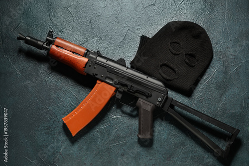 Balaclava with rifle on dar...