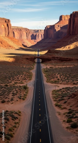 Majestic Desert Highway Stretching Towards Monumental Canyon Walls Under A Clear Blue Sky