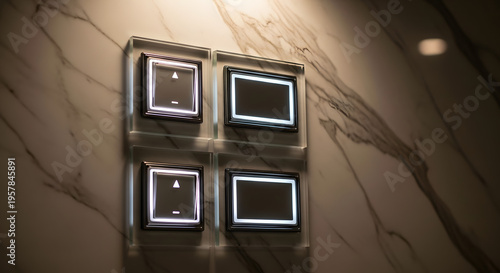 Modern minimalist light switch panel with illuminated buttons on a marbled wall