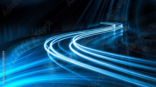 Photos Abstract long exposure photograph of vibrant blue light trails curving sharply on a dark, wet road, symbolizing speed