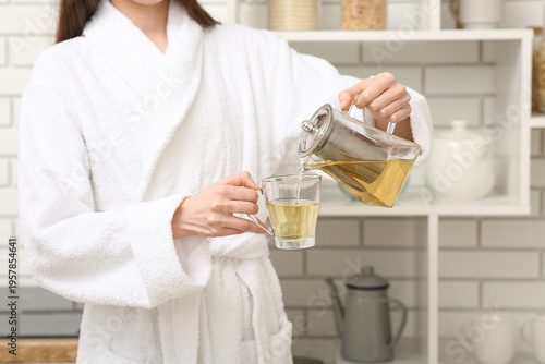 Young woman pouring tea fro...