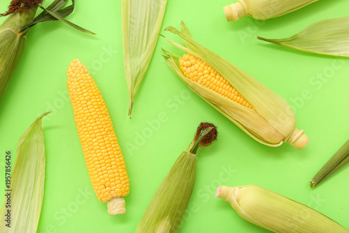 Fresh corn cobs on green ba...