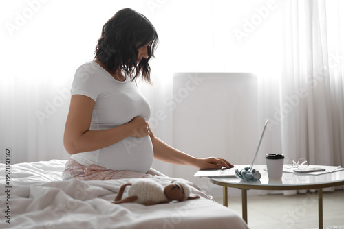 Young pregnant woman workin...