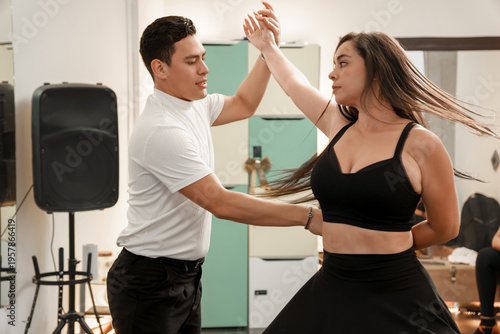 Tableau sur toile Couple dancing salsa performing steps in a studio