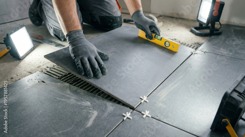 A man is laying tiles on a floor