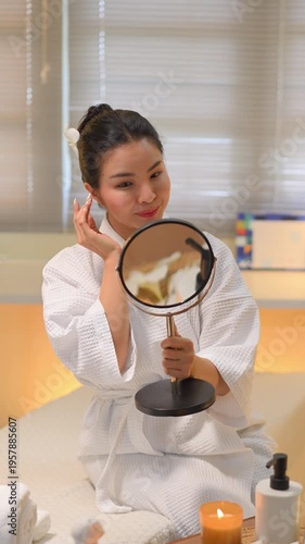 Woman checking skin in mirror at spa room, Vertical VDO wellness.
