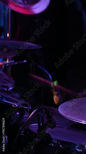 A rock band performs in a nightclub. Close-up of the drummer's hands.