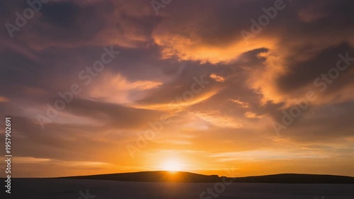 Vibrant orange sunset over a serene landscape with silhouetted mountains