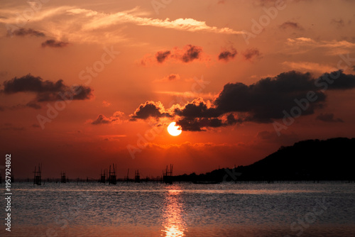 Golden Sunset over Songkhla Lake: Fish Cages and Mountain Silhouettes
