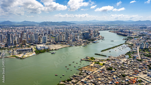 Aerial view of Itajaí port and city skyline along the riverfront on a sunny day.