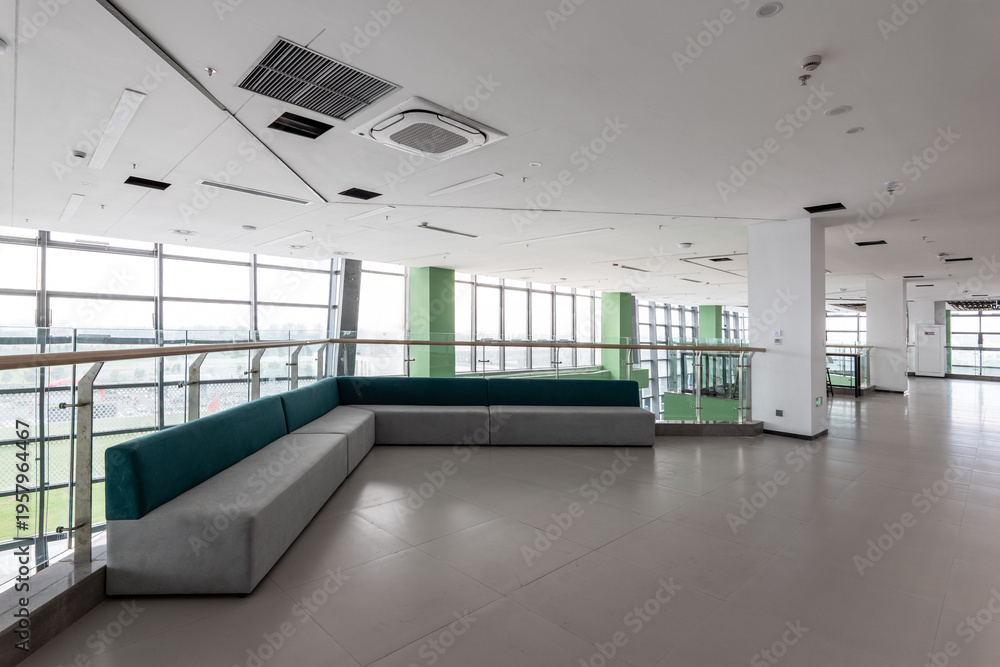 Fototapeta premium Modern office interior featuring green sofas in a spacious lounge area with large windows