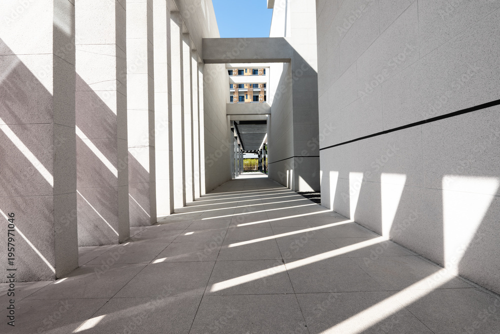 Naklejka premium Modern architectural corridor with intersecting light and shadow patterns
