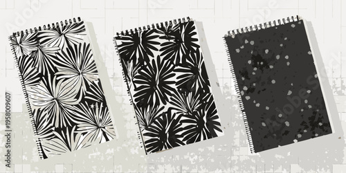 Three spiral notebooks with bold black and white tropical patterns displayed