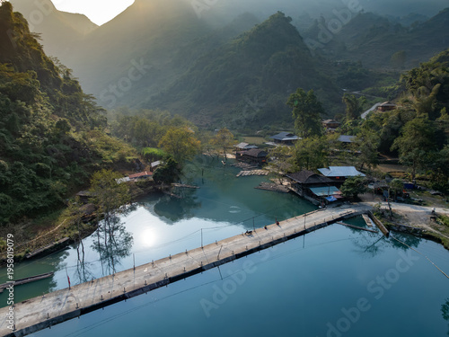 Quadro em tela A scenic view of Hang Than Lim, Yen Minh, Ha Giang, Vietnam, showcasing a bridge over a tranquil river, surrounded by lush mountains