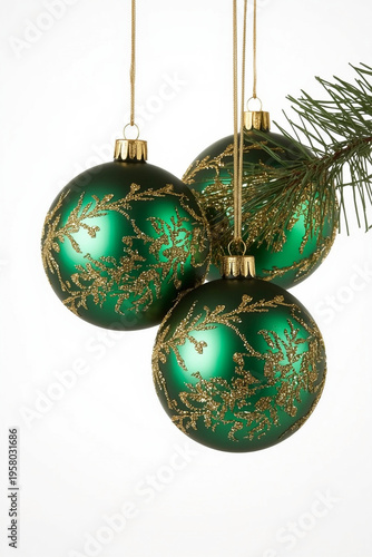 Three Green Christmas Baubles with Gold Patterns Hanging near Pine Branches on White Background