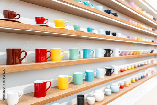 Photos Colorful Ceramic Coffee Cups including red, yellow, green, cyan, black and white Displayed on Wooden Shelves in Store