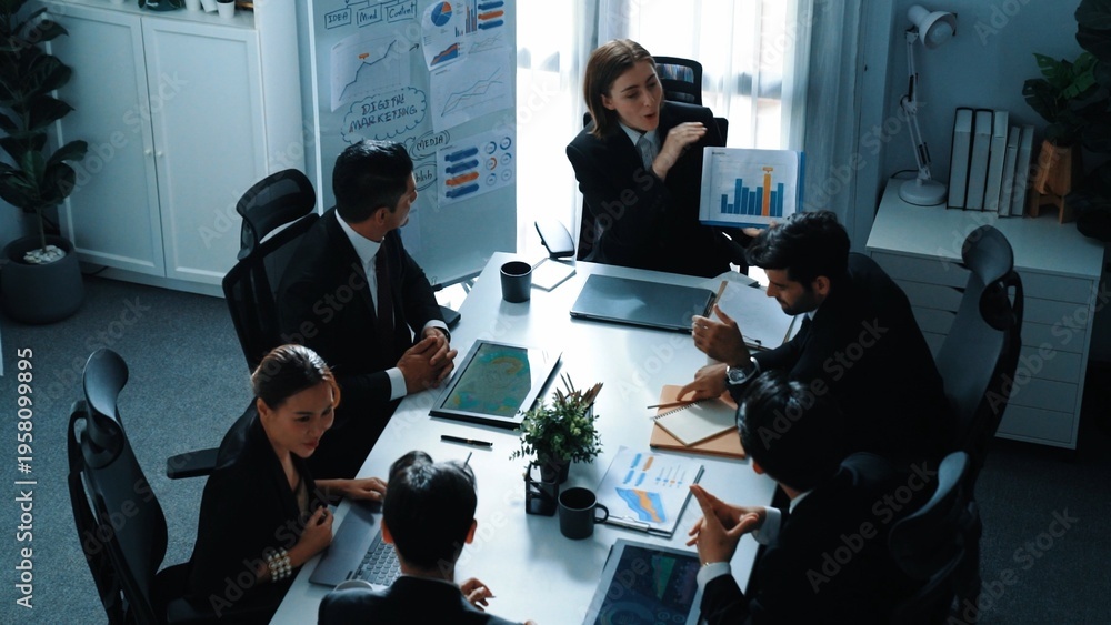 Fototapeta premium Top view of professional executive manager show increasing sales chart to diverse team while group of diverse business people listening and clapping hands to celebrate successful project. Directorate.