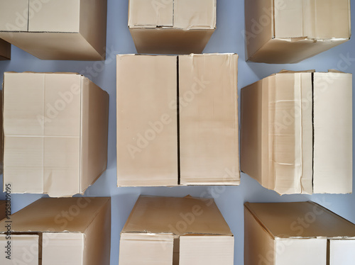 Top view of multiple sealed cardboard boxes arranged in a grid on a blue background, suggesting moving, storage, shipping, and delivery logistics.