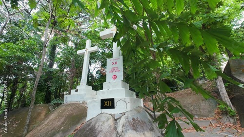 Outdoor depiction of the Stations of the Cross in a peaceful forest hillside. Ideal for themes of faith, spirituality, reflection, and religious observance during Lent.