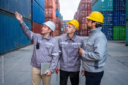 Engineer industrial workers males inspecting and pointing shipping container yard logistics and cargo operations