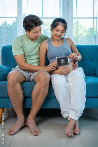 Asian expecting parents planning future family with ultrasound photo, pregnancy insurance concept