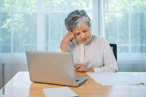 Serious Asian senior female manager working from home, business stress, remote office lifestyle and professional burnout concept