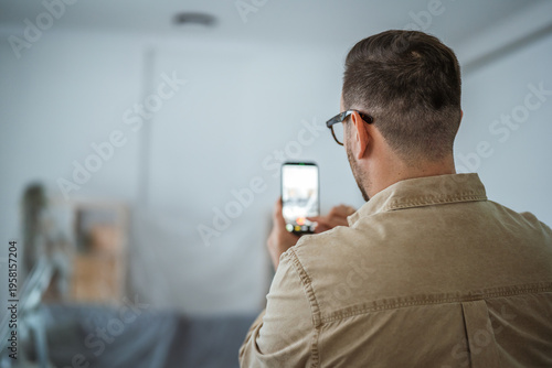 Man recording and documenting home renovation with smart phone