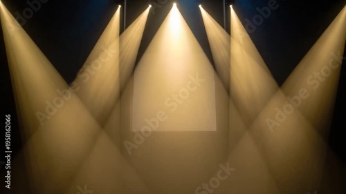 Overhead lights project warm beams onto a stage, creating a spotlight effect against a dark backdrop