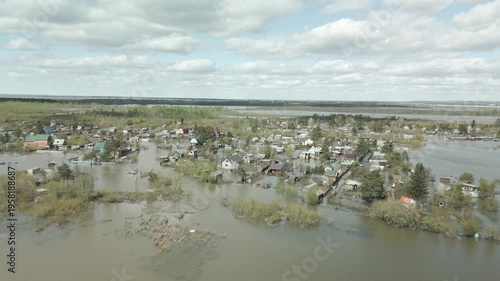 A spring large-scale flood disaster with fully submerged houses, flooded roads,and overflowing waterways. The footage shows the dramatic impact of heavy rainfall and rising water levels on residential