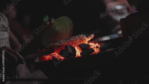 A warm orange fire burning in the dark fireplace creates a hot abstract background of yellow flames and glowing wood embers that radiate intense heat and light