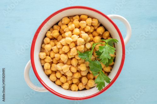 Food background with bowl of chickpeas salad over wooden surface. Top view. 
