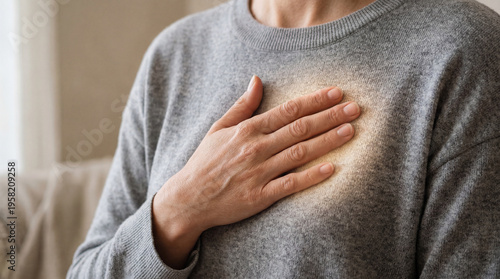 Silent burden's weight, a tender hand offers comfort to the chest, where a faint warmth suggests an unseen internal struggle