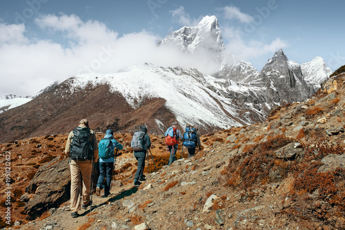 Group of tourists with backpacks walking mountain trail during hike of Trekking on Trail to Everest Base Campduring, Nepal.