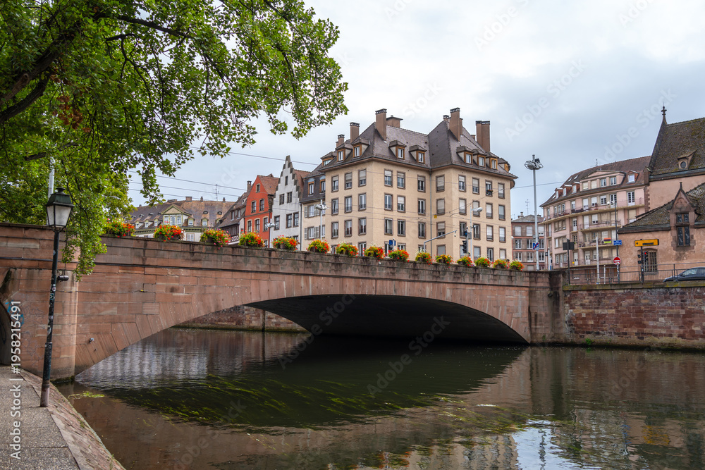Obraz premium Stone bridge with flowers crossing the Ill river Strasbourg, France