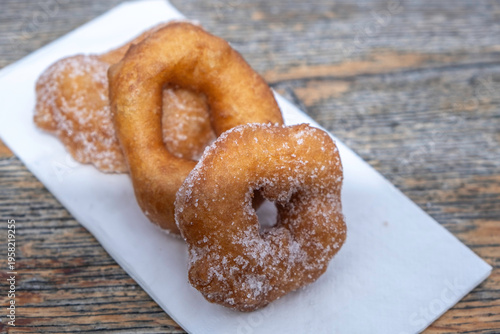 Food background with donuts on napkin over wooden surface.