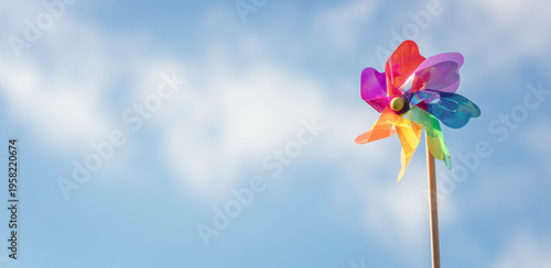 Summer or wind power renewable energy background, windmill or pinwheel against blue sky