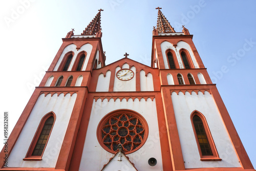 Sacred Heart Cathedral (Cathédrale du Sacré Cœur), red and white facade, double spires, slim windows, towers, rose window. Lomé, Togo.